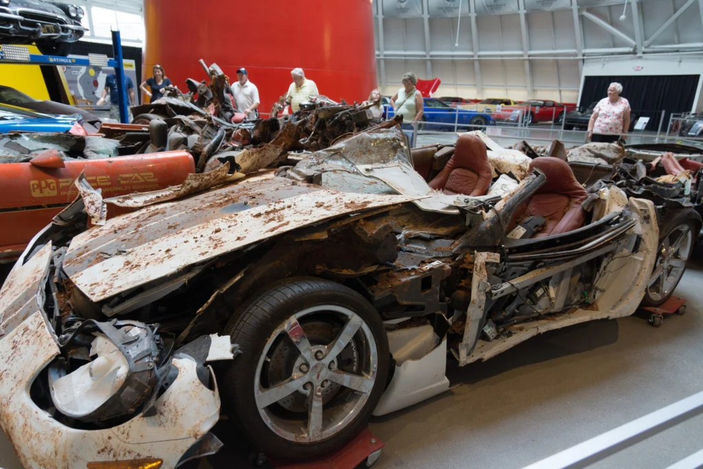 White C6-generation Corvette with a crushed body and exposed red leather interior on display at the National Corvette Museum