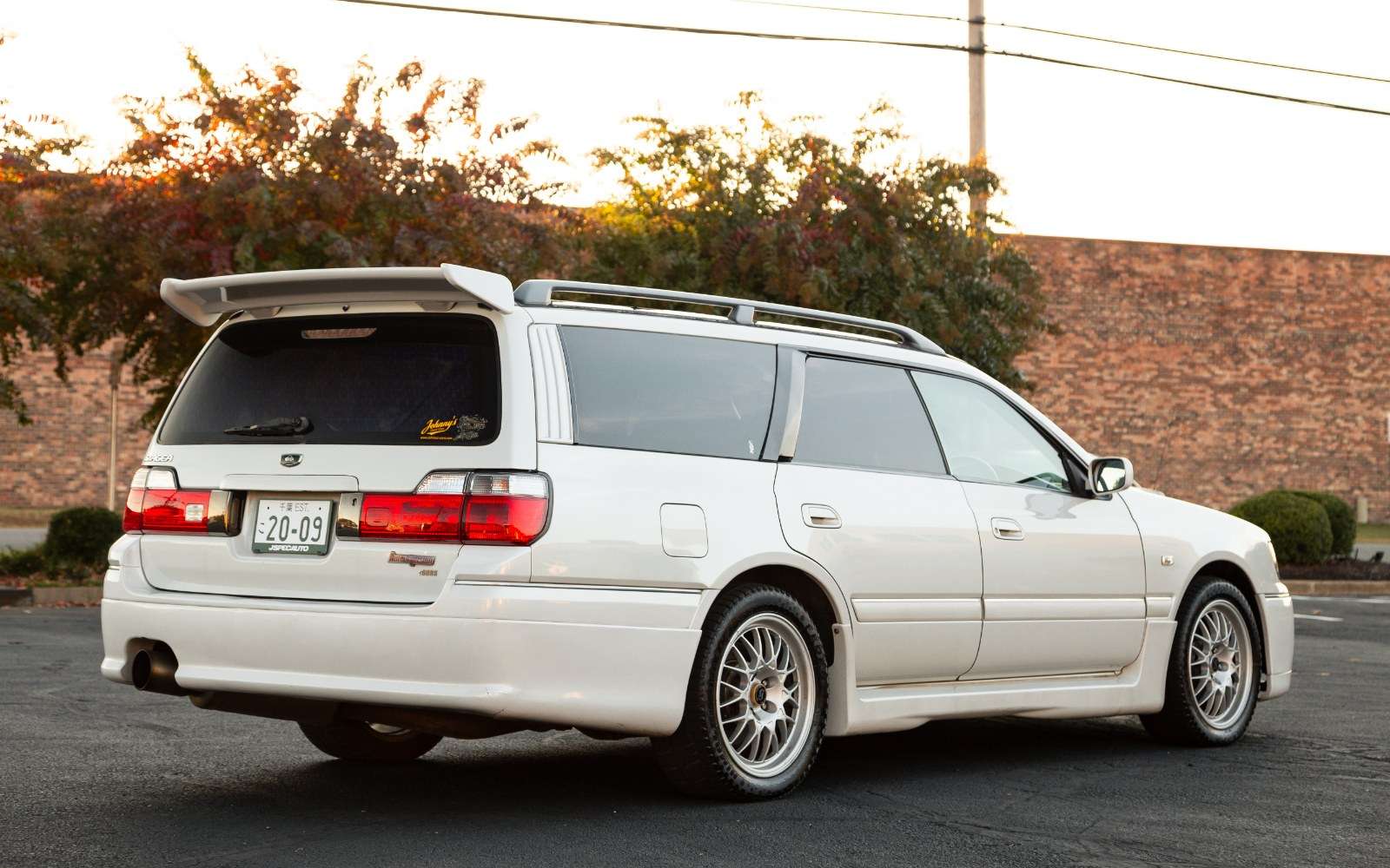 Rear three-quarter view of a white 1998 Nissan Stagea 260RS Autech Version wagon with tailgate spoiler
