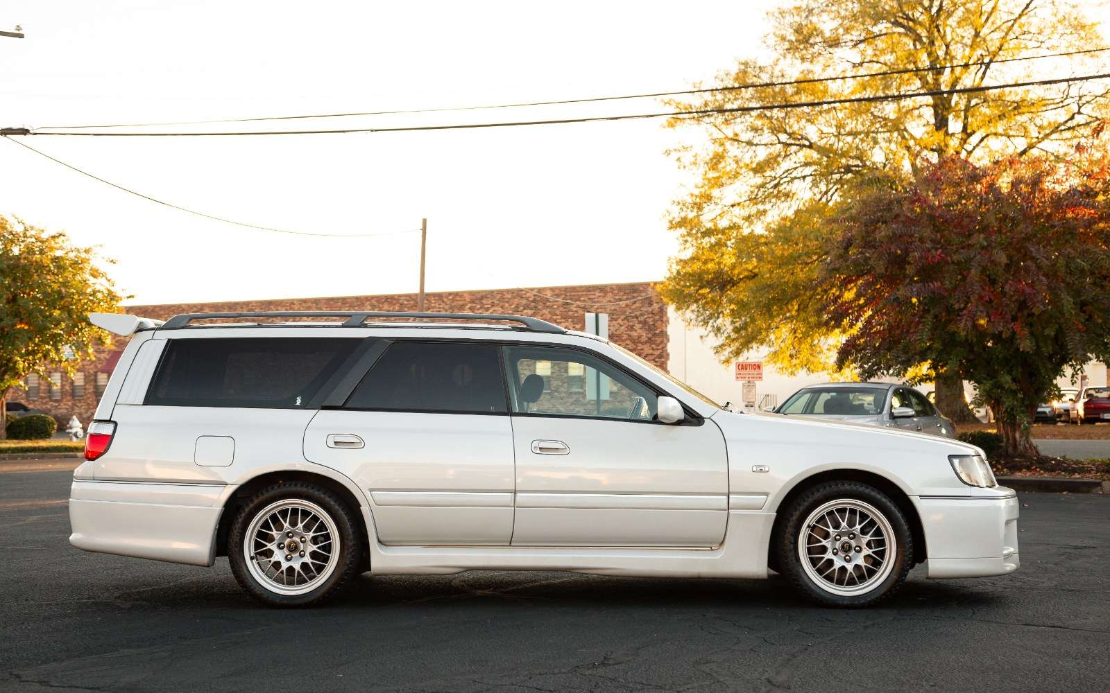 Side profile of a white 1998 Nissan Stagea 260RS Autech Version wagon on silver multispoke wheels