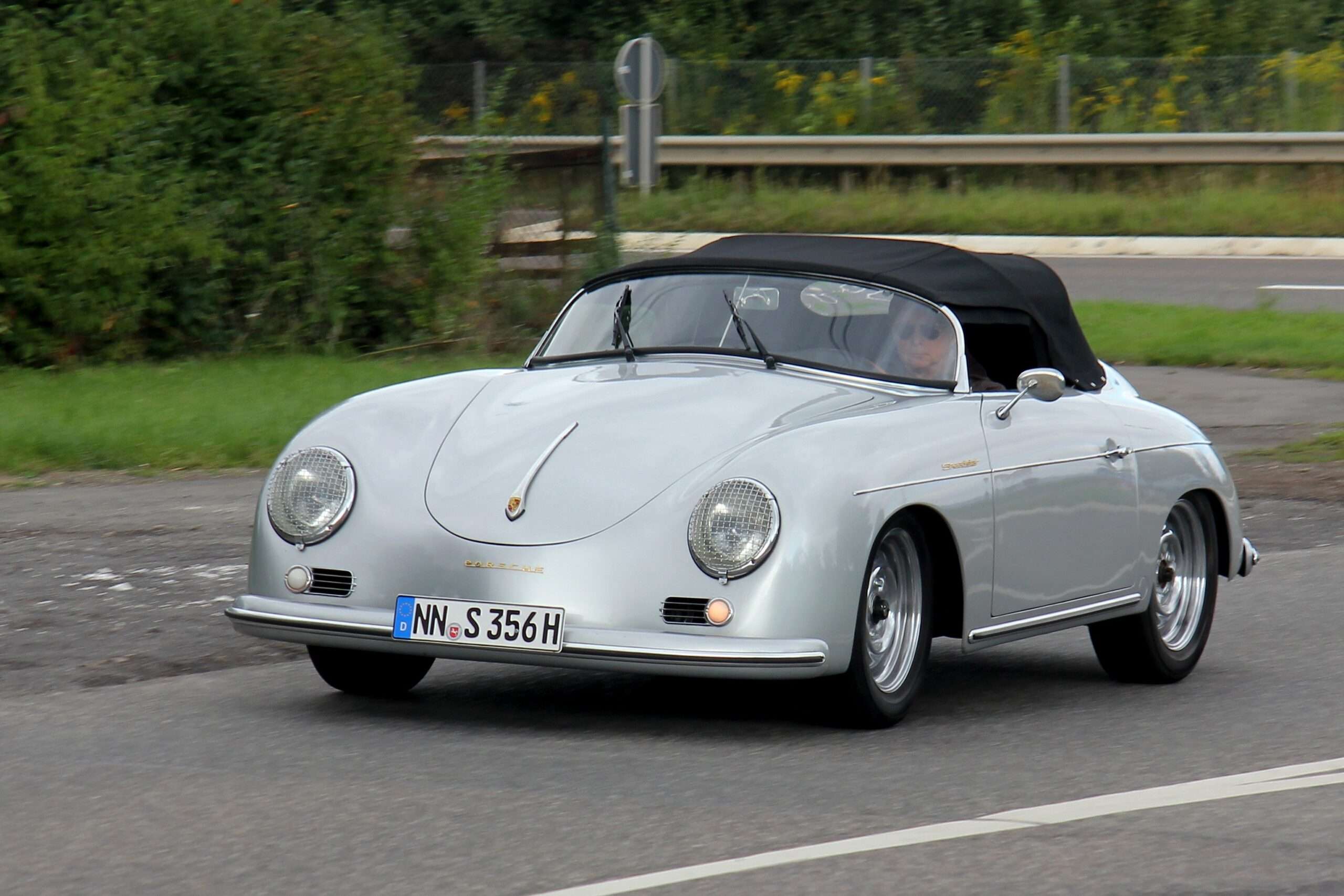 Silver Porsche 356 A Speedster driving with its black top raised