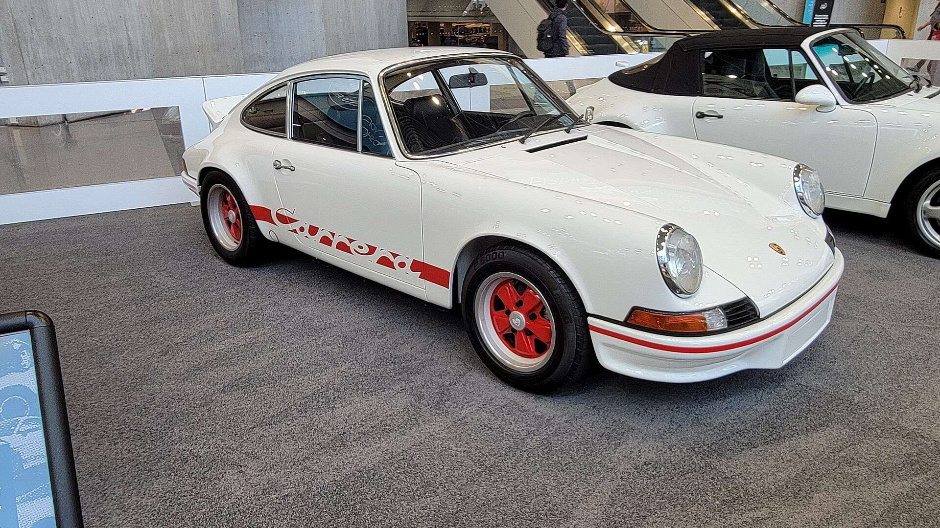 White 1973 Porsche 911 Carrera RS 2.7 with red side stripe and red-accented wheels in side profile