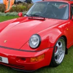Red 1994 Porsche 964 Carrera RS 3.8 parked on grass at the Concours of Elegance Hampton Court