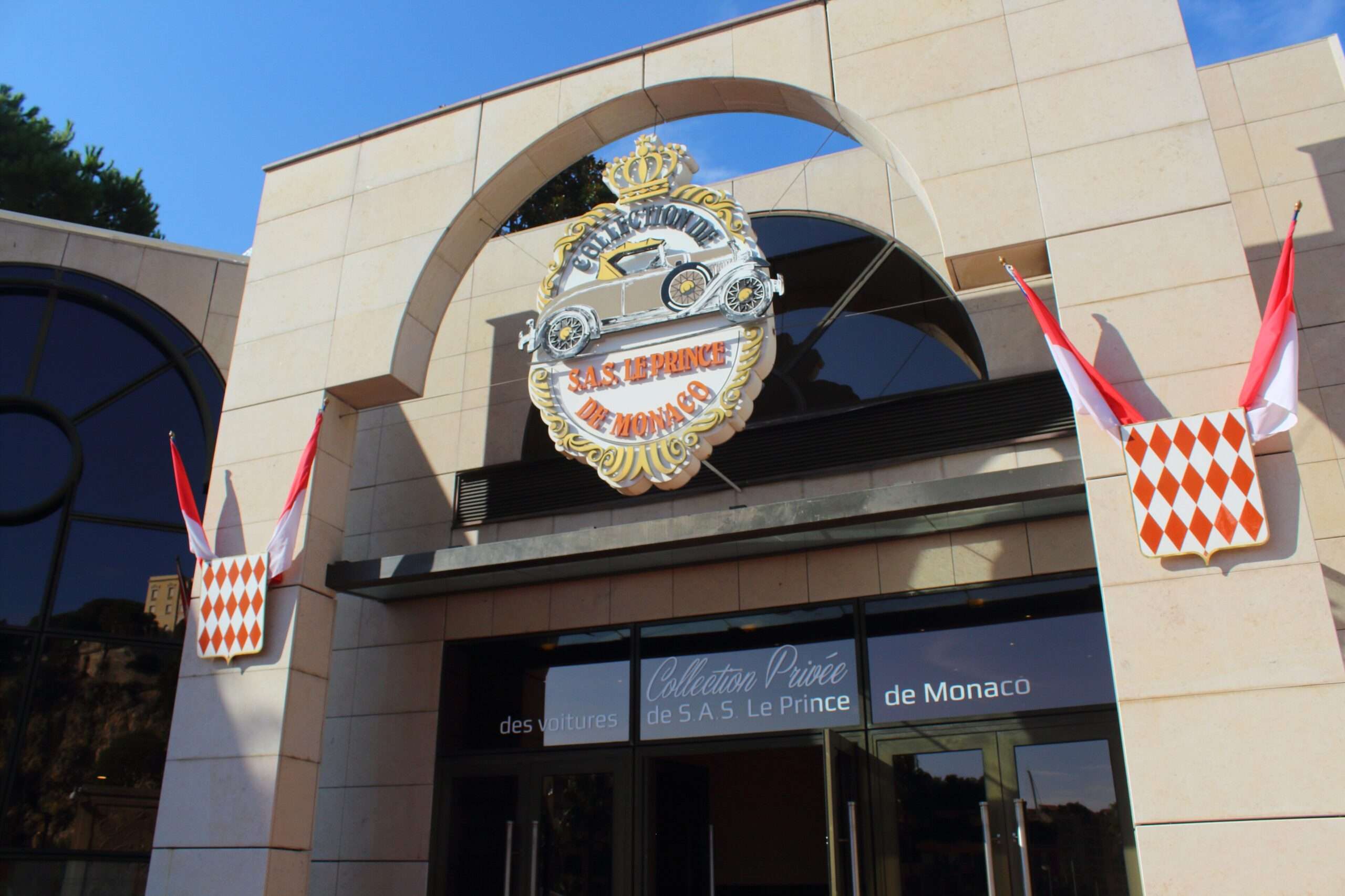 Entrance arch of the Prince of Monaco car collection at Fontvieille with the princely crest and Monaco flags