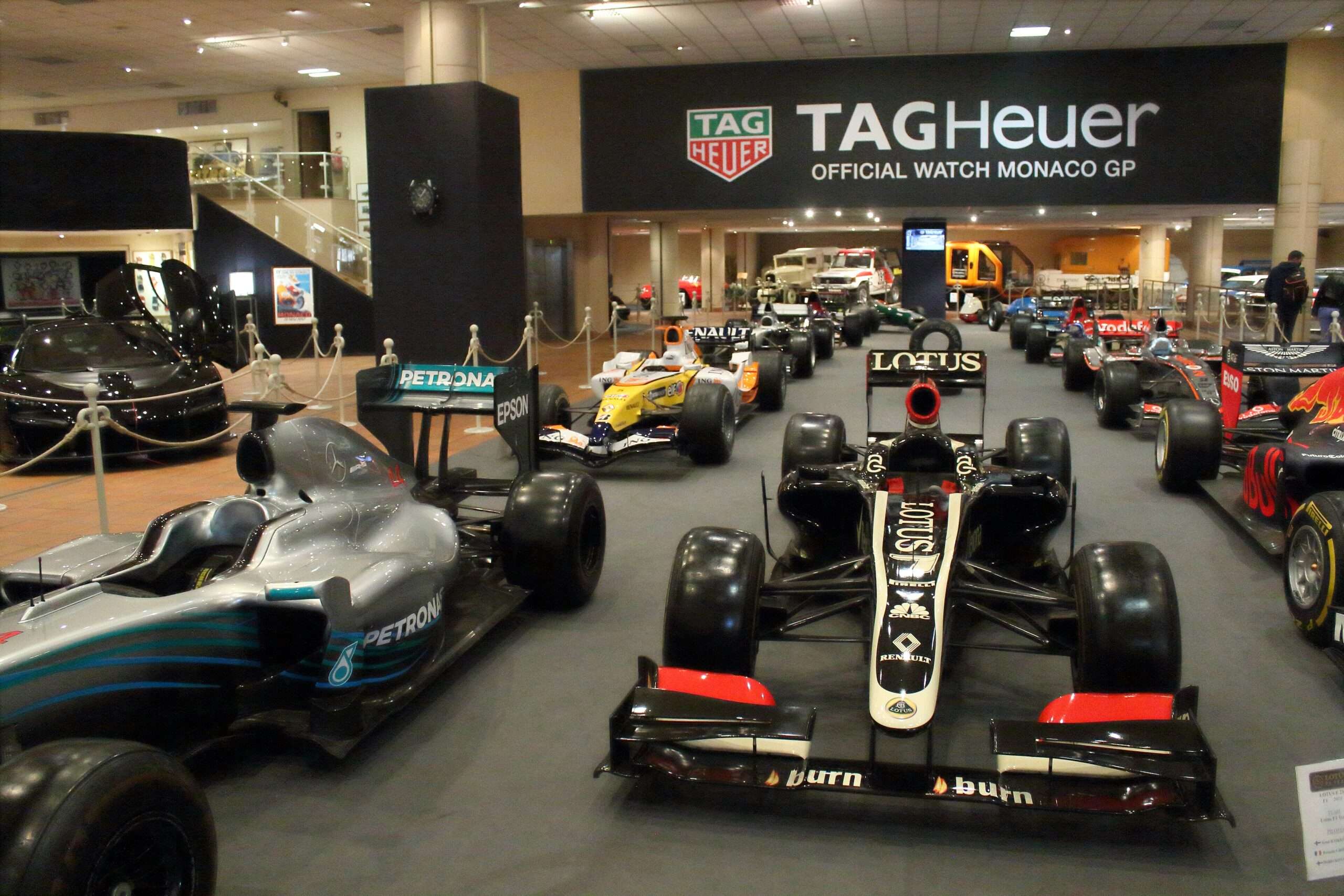 Rows of modern Formula 1 race cars, including a black Lotus, on display in the Prince of Monaco car collection