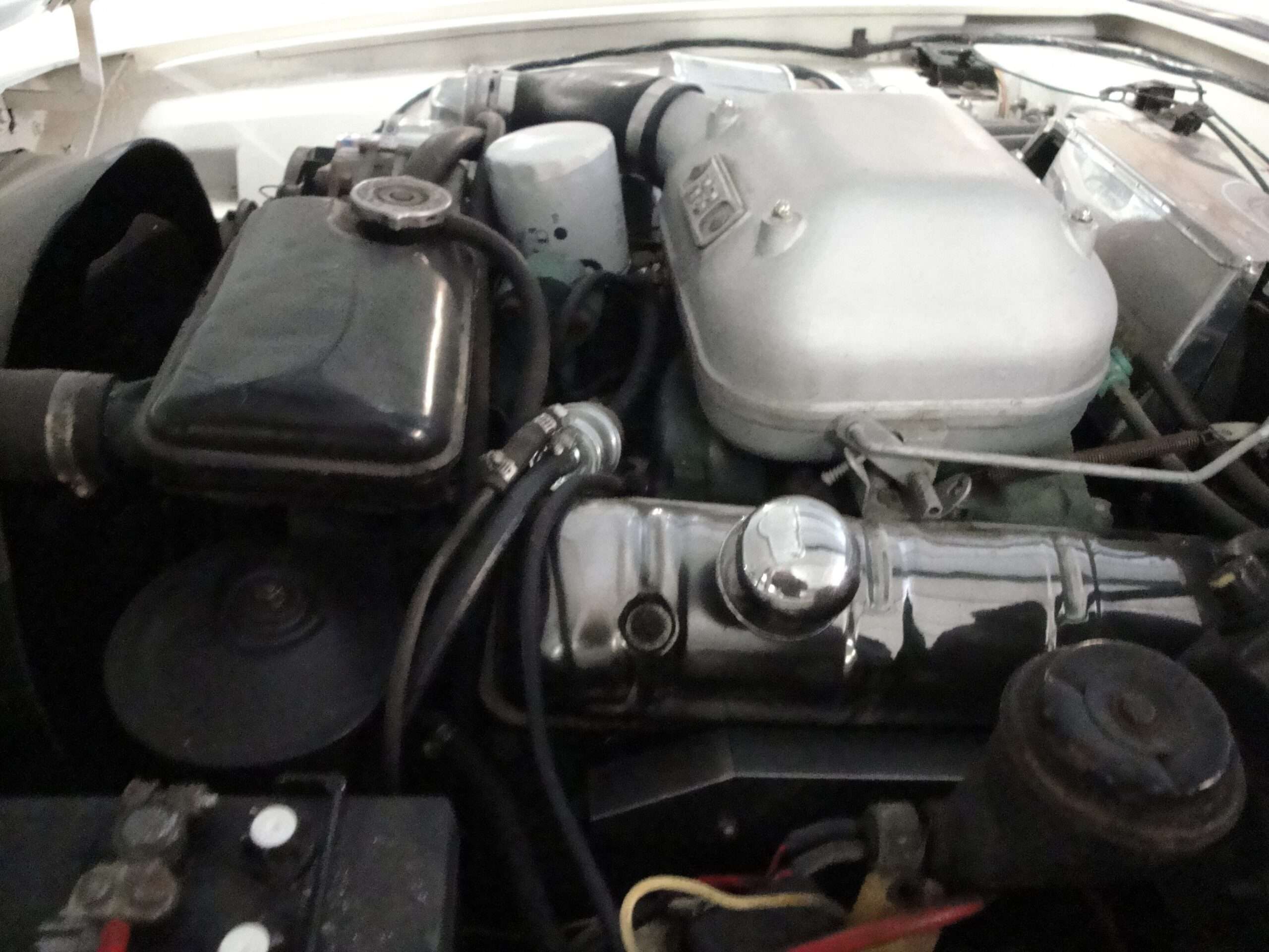 Supercharged Studebaker V8 in a 1963 Avanti engine compartment with the air box and plumbing visible