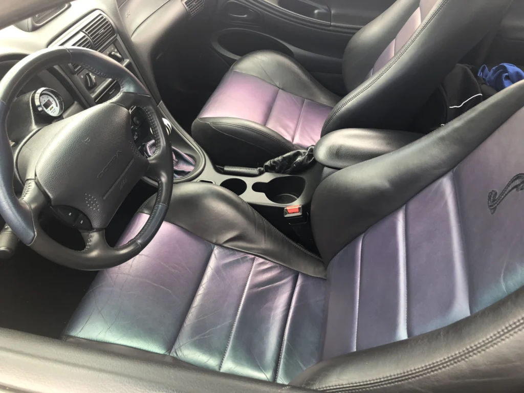 Mystichrome leather seats and steering wheel inside a 2004 Ford Mustang SVT Cobra, with color-shifting purple and blue seat inserts