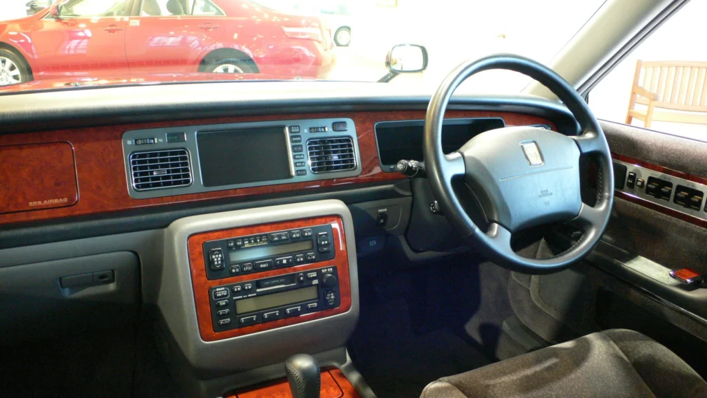 Right-hand-drive dashboard and wood trim of a first-generation V12 Toyota Century in a showroom