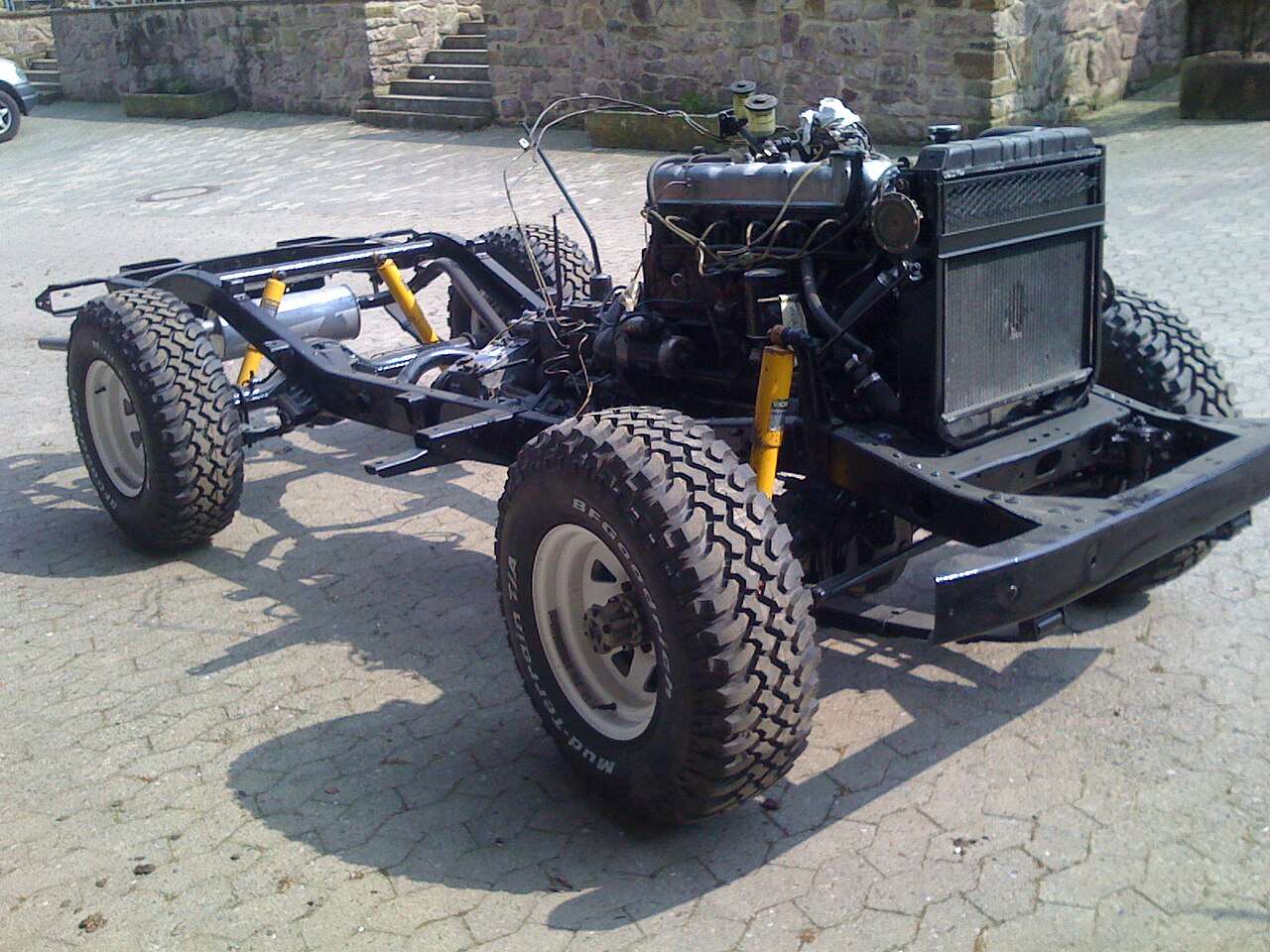 Underside of a 1978 Toyota Land Cruiser FJ40 showing leaf springs, live axle and frame with the original 2F engine