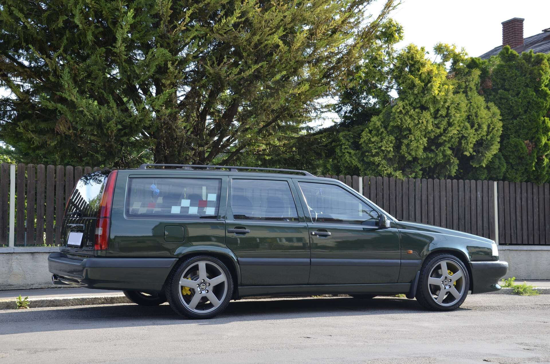 Dark green Volvo 850 T-5R estate in side profile on a street, showing the five-spoke alloy wheels